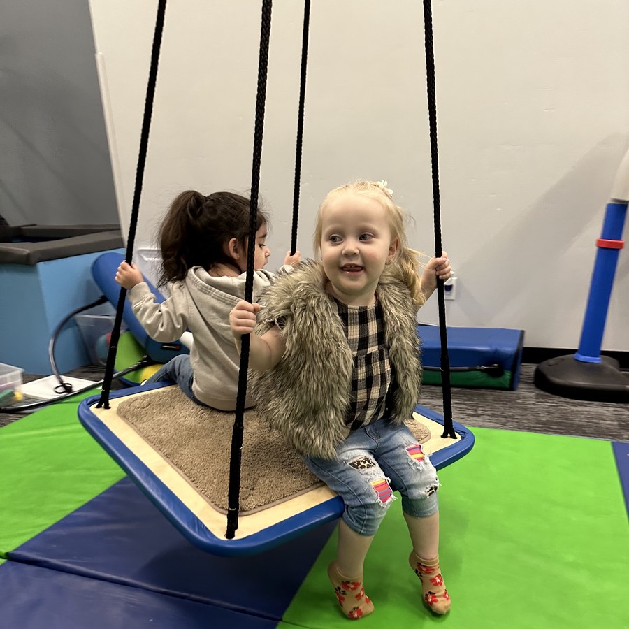 Children playing on therapy swing at Small Talk Pediatric Therapy